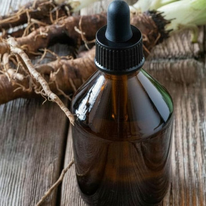 Amber herbal blood cleanser drops bottle with burdock root on rustic wood background