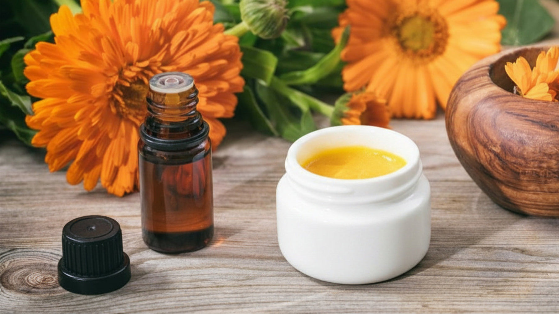SpeedyVite Deep Heat herbal ointment jar with calendula flowers and essential oil bottle on wooden surface