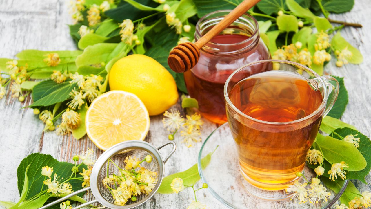 Herbal detox tea with honey and lemon on a wooden table