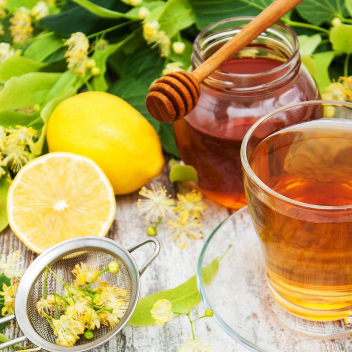 Herbal detox tea with honey and lemon on a wooden table