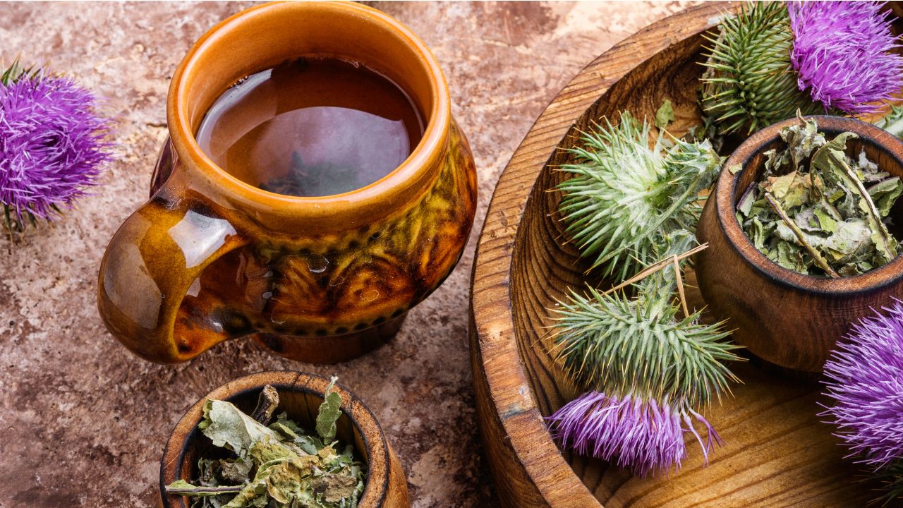 Herbal liver cleanse tea with dandelion and milk thistle herbs on wooden table