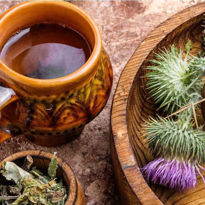 Herbal liver cleanse tea with dandelion and milk thistle herbs on wooden table